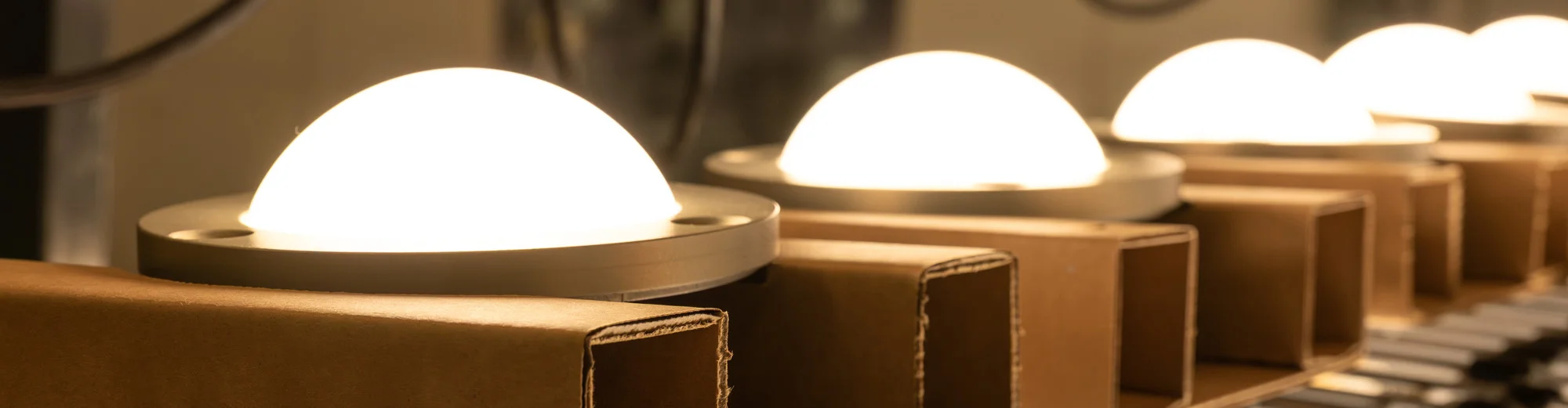 A row of domed light fixtures on an assembly line